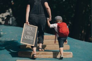 Mother packing childrens first aid kit before school