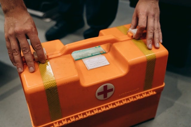Workplace first aid room with wall-mounted kit and supplies