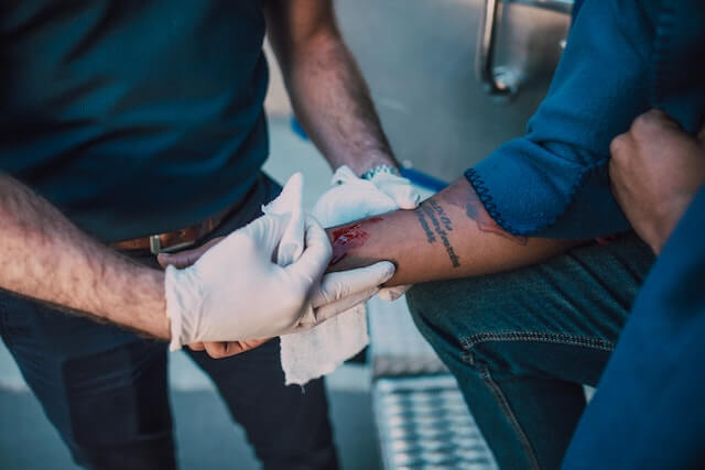 Bleeding disorder first aid with pressure dressing and gloves