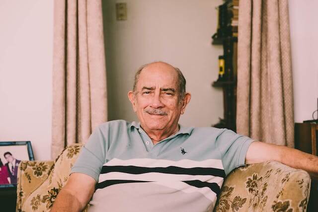 Senior receiving first aid for fall injury at home